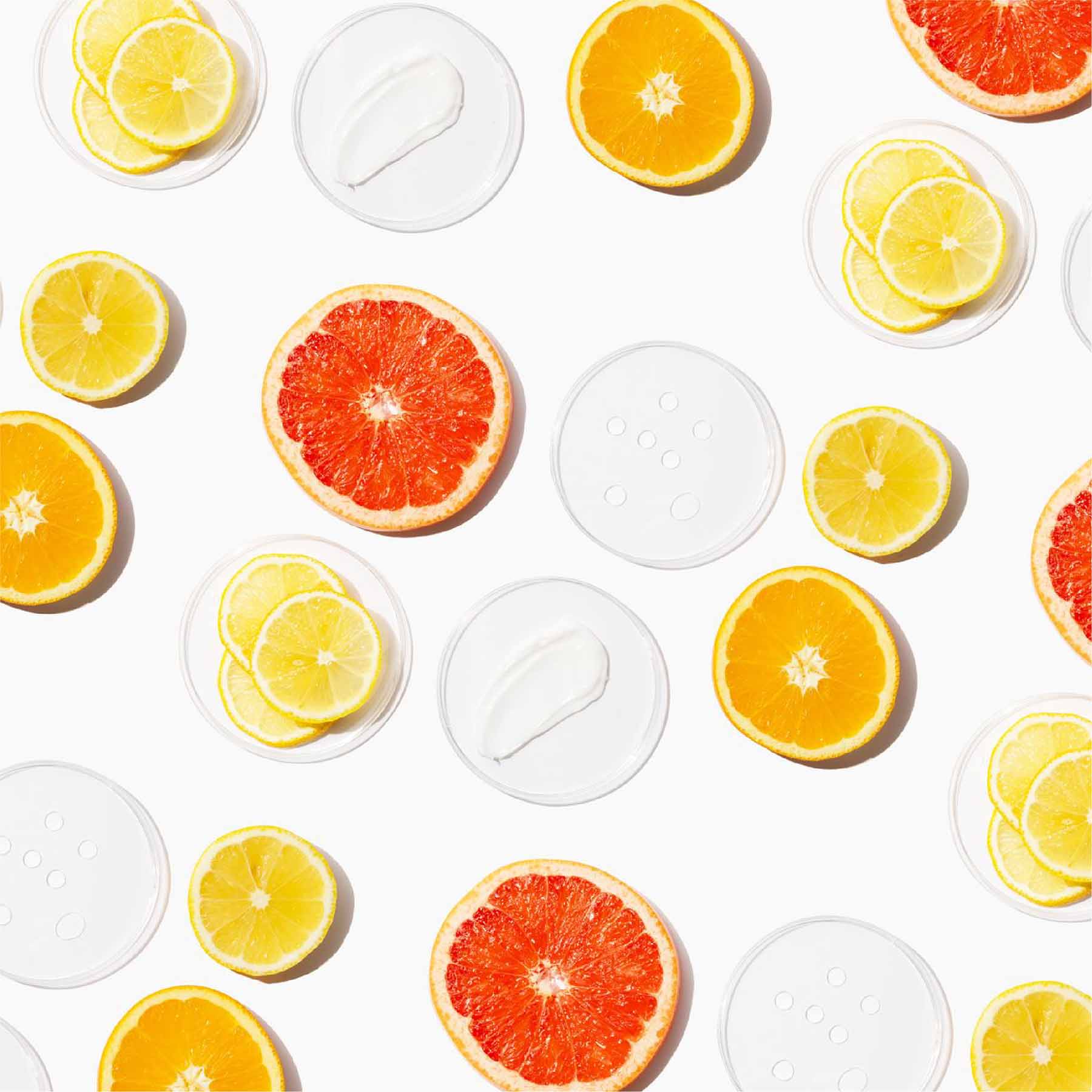 citrus fruit flat layered and in a pattern on a white backdrop